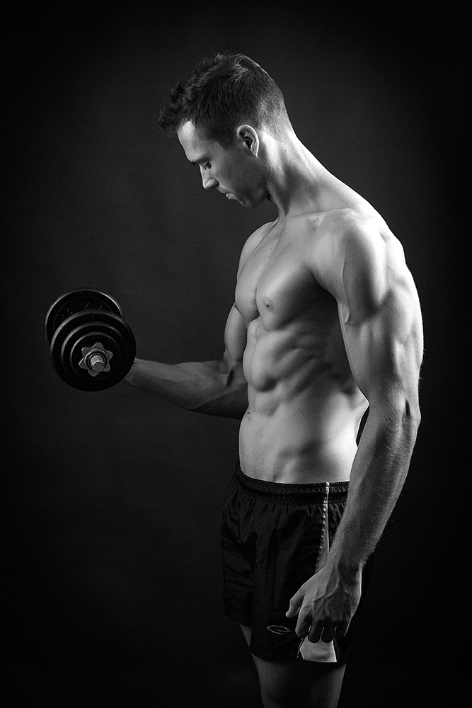 Biceps Training Tips I’ll admit it, when I first made the decision I was going to transform my physique for the better I went to my local sports store and bought a 25lb dumbbell set. What followed was a month of biceps curls, every variation I could find as well as some that’d probably never been seen before. Once a week I snapped a photo of my arms and measured my biceps peak… no change. I became discouraged and never touched those dumbbells again. Several months later when I started following a proper workout regime and discovered the training principles that actually work I realized that I’d make literally every single mistake possible on the quest for big biceps. TheronKPhoto_0098 Back then my arms, at 16% body fat measured 12″, today in the single digit body fat range they are just shy of 17″. Here’s what you need to know in order to build those biceps you’re envisioning. Want Big Biceps? Here Are My Top Tips Lower Your Rep Range Just because the biceps are a far smaller muscle group than your back or legs it doesn’t mean they require any different treatment in terms of workout structure. Performing 20, 30 or 40 rep sets will burn and give you an absurdly large pump, however the burn is merely the build-up of lactic acid and the pump is the temporary rushing of blood to the targeted muscle. Since I started training biceps utilizing the principles I focus on for other body parts I’ve managed to overcome plateaus and build immense strength. Keep your biceps workout simple and start with the big mass movers before you delve further into isolation. Form is paramount, but lift heavy enough to ensure you’re only able to get around the 6 rep mark Don’t overdo the volume, 3 – 4 exercises is more than enough, no need to do 10 variations of the same exercise Use An Arm Blaster To Lock In Perfect Form You can focus on the right exercises and lift heavy for the recommended rep range, but if your form isn’t on point you’re not going to be getting the size and strength gains you want. Swinging and flaring your elbows as you attempt to curl the weight are two textbook signs you’re lifting too heavy. arnold-schwarzenegger-dumbbell-curls An arm blaster is a fantastic way to lock in good form. So what is an Arm Blaster? An arm blaster is a harness with a metal plate. The harness slides over your neck, allowing you to lock your arms into the grooved sections of each side of the arm blaster’s metal plate. How does an Arm Blaster work? The arm blasters primary purpose is to ensure greater isolation on the biceps when performing different variations of bicep curls e.g. EZ curls and dumbbell curls. This isolation is achieved due to the grooved sections of the arm blaster holding your elbows in place. When performing a traditional bicep curl without an arm blaster when your form begins to deteriorate the natural thing to do is to begin to use momentum and swing backwards with your elbows to muscle the weight up. The arm blaster holds your elbows firmly in place, forcing your biceps to work harder to curl the weight up as they no longer have any assistance. This is a simple yet fantastic concept as greater isolation means greater tension and stress on the muscle,greater stress and tension on the muscle will promote potential growth in your biceps. Stop Swinging Every guy in the gym wants to swing around heavy weight on biceps, I get that. As I said earlier – if you want to build big arms you’re going to have to lift heavy, HOWEVER form always have and always will take priority over the weight being lifted. The bottom portion of a bicep curl is without a doubt the hardest portion of the movement, and when lifting too heavy many gym-goers attempt to swing backwards or hip thrust to attempt to move the weight. Using momentum to move the weight takes tension off the bicep, doing you no good. If you’re swinging and swaying your back on every repetition you’re also placing your lower back at a high risk of injury – not good. Pick a weight that’s heavy for you to perform with good form, save the cheat curls for Arnold. Hit The Hammers Dumbbell Hammer Curl The dumbbell hammer curl (palms facing inwards) are a fantastic mass builder for the biceps, I have quite a long biceps insertion (meaning my biceps peak isn’t as prominent as someone with a short biceps insertion). At first I accepted that I’d never be able to build a solid bicep peak as I had been robbed by my genetics… I was wrong. After spending months hitting heavy seated dumbbell hammer curls my biceps peaks started to grow! To this day the dumbbell hammer curl is a staple exercise in my arm workouts. Hammer curl can be performed with a bicep blaster to ensure your form remains strict while lifting heavy too. Apply Progressive Overload The term progressive overload simply means to constantly ensure your muscles fibers are being subject to a larger load or an increase in tension on the muscle, essentially placing more stress on the muscle resulting in an increase in both muscular size and strength. You should be applying progressive overload in every single workout you’re performing. Increase the weight The most basic method of applying progressive overload to your muscles for size and strength gains is to increase the weight you’re lifting. As an example, if you’re aiming for the 4- 6 rep range for 3 sets and you’ve been consistently hitting 6, 6, 5 for your last 3 sets increasing the weight, even though you’re reps will more than likely drop down to 5, 5, 4 is a sufficient form of progressive overload to keep your strength and size on the rise. Alter your rep range The thing I repeat the most on Ignore Limits is without a doubt the importance of training in the lower rep ranges. If you’ve been spending day after day performing 10 repetitions by default on each and all of your sets then you’re going to be doing your muscles a massive favour by decreasing your rep range down to 4 – 6. Lifting a suitable weight for 4 – 6 repetitions (which should be 80 – 85%) of your 1 rep maximum will blast your strength and size to new levels. Alter your number of sets Several years ago when I hit a plateau on my shoulder press I tried everything I could think of to get past it, it seemed as if I’d never get past the 55lb mark on those dumbbells. The solution? Because I didn’t have a spotter I couldn’t lift any heavier so I opted to increase my volume my reducing the rep range slightly while increasing the number of sets (resulting in an increased number of heavy reps per workout). Example: 3 sets of 8 reps was adjusted to 5 sets of 6 reps. Stop Chasing The Pump First of all, what is the “pump?” The pump is the tight feeling caused by blood rushing to the targeted muscle in the body part you are training after performing multiple sets. The pump alone does not indicate that you are making progress or that your muscles are growing – a high repetition set of push-ups can be used to obtain a pump, meanwhile dumbbell bench pressing 130lb dumbbells for 5 reps may not give you a pump even though this lift and weight is far more beneficial towards growth. Scott-041bw As discussed earlier, applying progressive overload with heavy compound movements in the 6~ rep range will build mass and strength, if you’re constantly chasing the pump with lighter weights your big arms will only last for the duration of your workout. When you’re curling a 135lb barbell for 6 strict reps you won’t need to worry about the pump or the size of your arms, they’ll take care of themselves. Focus On The Mind Muscle Connection The primary reason for improving your mind muscle connection is to increase the number of muscle fibers recruited while lifting and increasing the contraction of the muscle on each repetition. Increased recruitment and contraction will result in increased muscle mass and strength, this involves being able to control, fire and relax the muscle in question on demand. Can you bounce your pecs up and down? This takes a degree of established mind muscle connection to perform properly (without twitching your shoulders!). Tense the muscle prior to each set Before each set flex and hold for a count of two seconds before picking up the dumbbells/barbell and lifting. I find this techniques helps me maintain a strong mind muscle connection when performing pull-ups – by taking a moment to bring my shoulder blades together and contract my lats I’m able to hone in on the muscle better and ensure I’m pulling through my lats as opposed to my biceps as fatigue sets in. Perform several lighter weight perfect form war-up sets A huge mistake guys make when they get to the gym is warming up incorrectly. Not only will you not feel an optimal mind muscle connection but you’re also at a much higher risk of injury if you neglect your warm-up or don’t perform one at all. Instead of performing a few basic static stretches (which have actually been proven to decrease your performance when it comes to explosive strength based exercises) I recommend you follow a slightly more dynamic warm-up. Visualize Before you lay on that bench and get under the barbell take a moment to mentally ‘check in’ and envision the set you’re about to perform. Imagine lowering the barbell in a controlled manner to your chest while feeling the stretch across your pectorals before exploding upwards and squeezing your chest together to get that contraction at the top of your repetition. I’ve found when I don’t take a moment to envision honing in on the muscle I’m training I often end up unconsciously recruiting secondary muscle groups (such as the shoulders since we’re discussing the flat barbell bench press). Now that you’ve already mentally played out your set you’ll feel a far greater level of control and contraction throughout your set